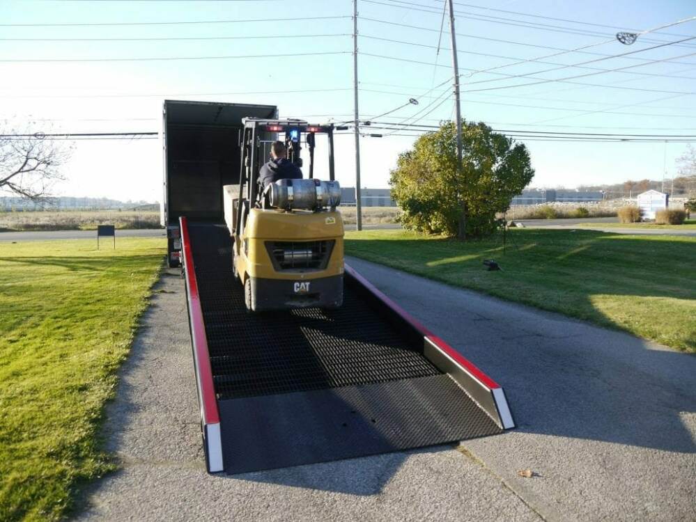Yellow forklift traveling up a Copperloy yard ramp | Rent a ramp